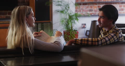 Relaxing at Home: Woman Reading and Man Using Laptop on Couch