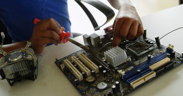 Young technician soldering computer motherboard components - Download Free Stock Photos Pikwizard.com