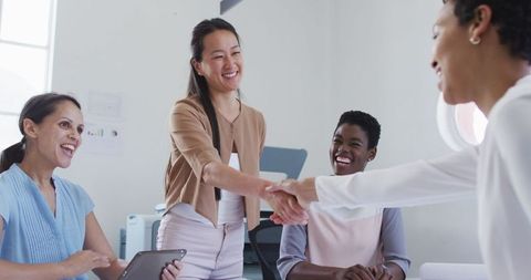 Diverse Businesswomen Meeting Shaking Hands in Modern Office