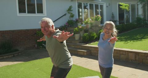Smiling Senior Couple Enjoying Outdoor Yoga Stretches Together