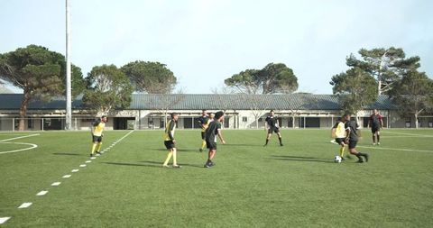 Young Soccer Players Engaging in Match on Green Field