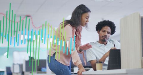 Diverse Coworkers Analyzing Data with Overlaid Graphs in Office