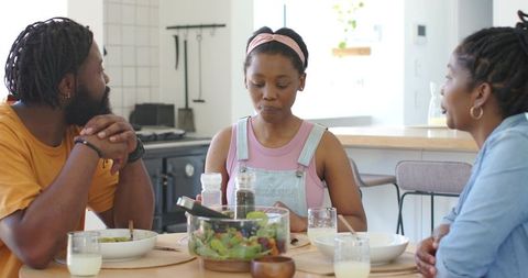 African american family sharing healthy meal around kitchen table