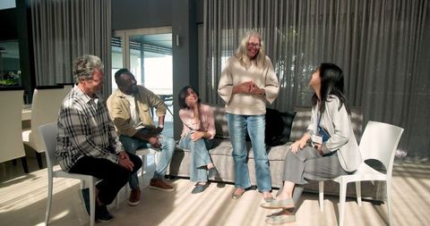 Diverse group engaging in therapy session in sunlit room