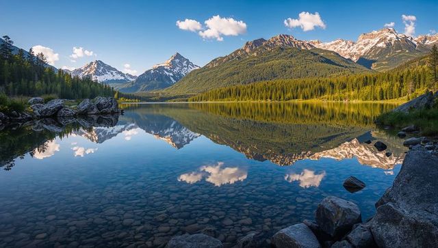 Tranquil alpine lake reflecting snowcapped mountain range and pine forest during sunrise