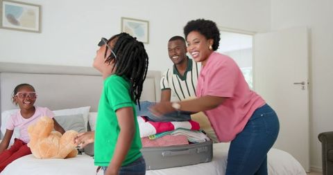 Happy Family Packing for Vacation Together at Home