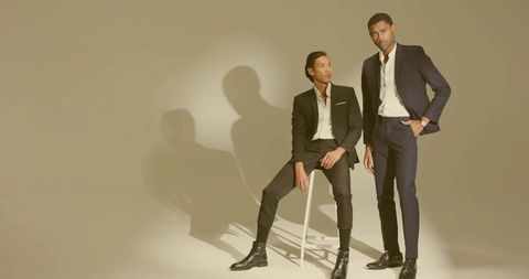 Stylish men in elegant tailored suits posed in studio