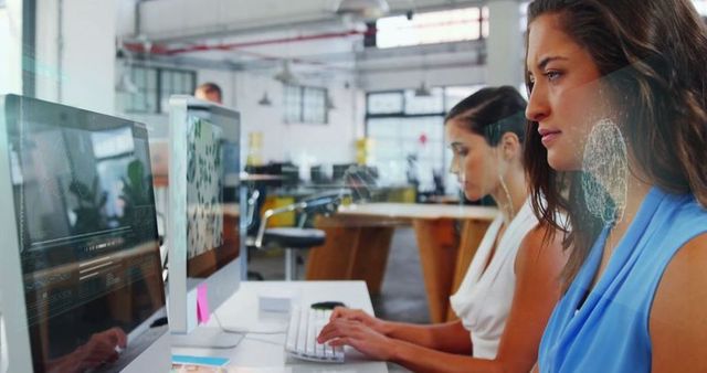 Focused Women Working in Open Plan Office on Computer Monitors