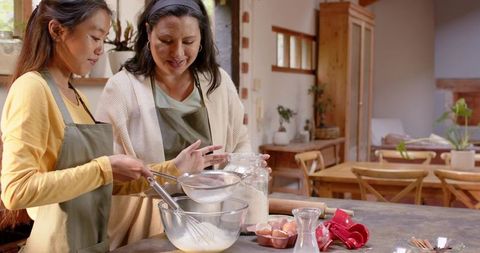 Mother and Daughter Baking Together in Rustic Home Kitchen