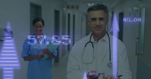 Doctor Reviewing Data with Technological Graphics in Hospital Corridor