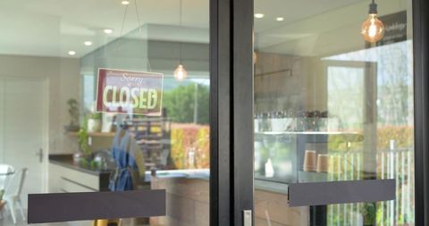 African american barista preparing coffee behind counter in cozy cafe with closed sign