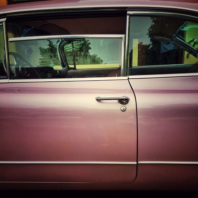 This image showcases the door of a classic purple car with chrome accents, perfect for use in automotive websites, vintage vehicle blogs, retro-themed marketing materials, car restoration guides, and design inspiration resources.