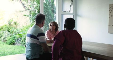 Senior Couple Conversing With Caregiver in Bright Living Space