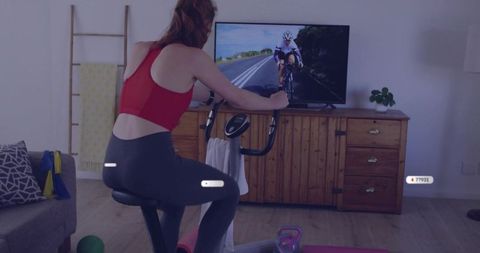 Woman Exercising on Indoor Bike Watching Cycling Video