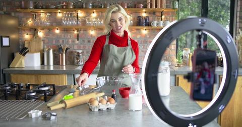 Content creator filming baking tutorial with ring light in cozy kitchen teaching pastry