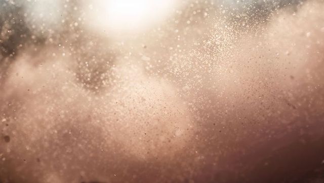 Macro foam and glitter particles floating in warm light, abstract textured bokeh surface