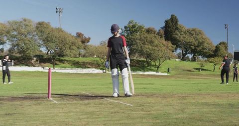 Female Cricketer Ready to Bat on Sunny Day