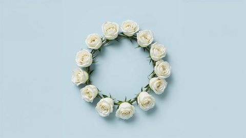 Ivory white rose wreath on pastel blue background for condolences