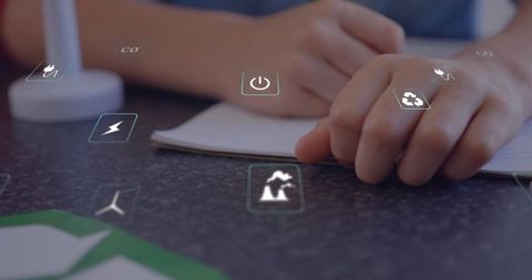 Children writing in notebook with glowing holographic energy icons, studying sustainable power