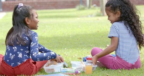 Two Young Girls Enjoying Outdoor Picnic at School