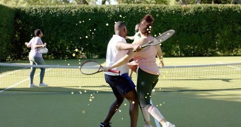Playing mixed doubles at net on sunny grass court, dynamic rally and teamwork