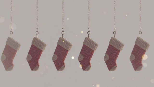 Six hanging red knitted christmas stockings with white cuffs swaying with bokeh lights