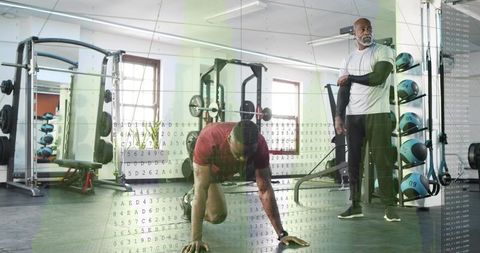 Athlete performing bear crawl workout while coach observing in gym with data overlay