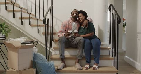 Happy Couple Enjoying Coffee While Unpacking in New Home