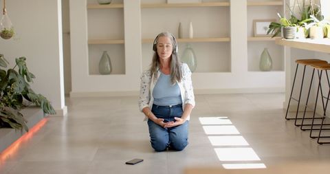 Woman with Grey Hair Meditating at Home in Serenity