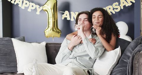 Couple Celebrating Anniversary with Champagne in Cozy Living Room