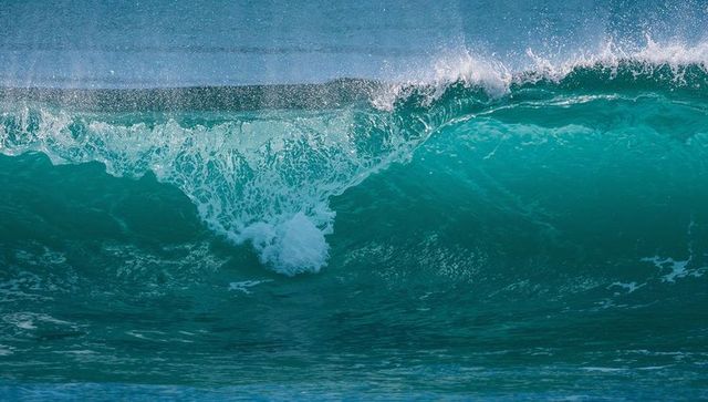 Turquoise Ocean Wave Curling with Translucent Lip and Sunlit Spray