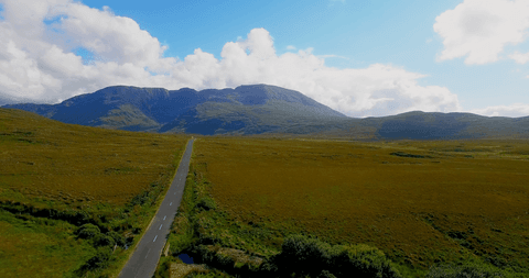Tranquil Transparent Road Amidst Lush Landscape and Majestic Mountains - Download Free Stock Videos Pikwizard.com