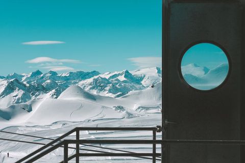 Scenic snow-capped mountains through circular window