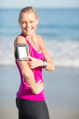 Portrait of smiling woman using transparent arm band with smartphone