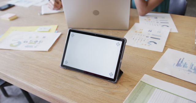 Business professionals collaborating on financial documents and data analysis using a tablet in a modern office. Ideal for visuals related to office settings, teamwork, financial data analysis, presentations, and business environments.