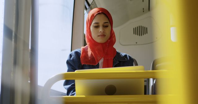 Confident Woman in Red Hijab Working on Laptop While Traveling by Bus - Download Free Stock Images Pikwizard.com