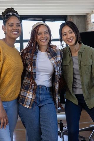 Diverse Team of Women Smiling in Modern Office Setting
