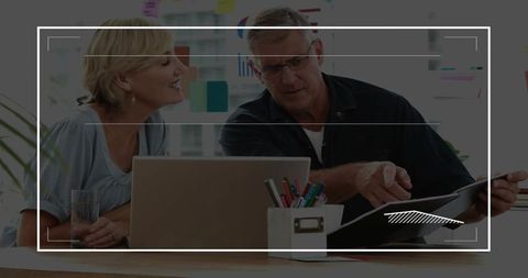 Senior Couple Collaborating on Financial Planning Using Laptop and Documents