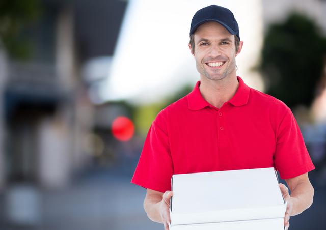 Digital composite of Happy deliveryman with pizza boxes in the city