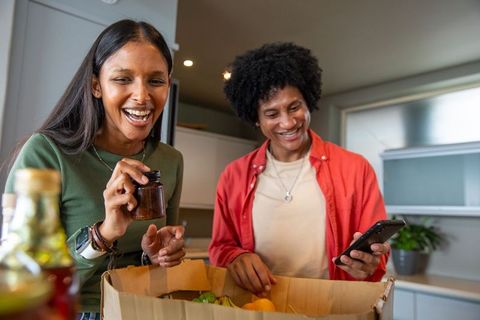Couple Unpacking Groceries With Joyful Expressions in Modern Kitchen