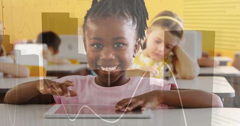 Smiling African American girl using tablet in classroom with data graphs overlay for edtech