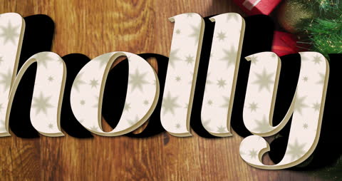 Festive Holly Text with Christmas Decorations on Wooden Surface