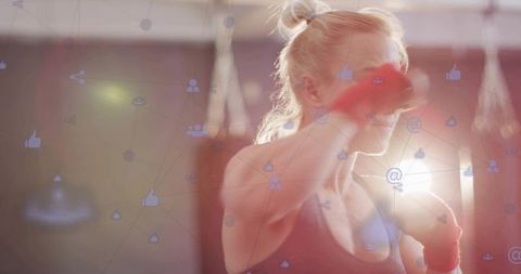 Female boxer jabbing with red hand wraps in backlit gym with social media overlay