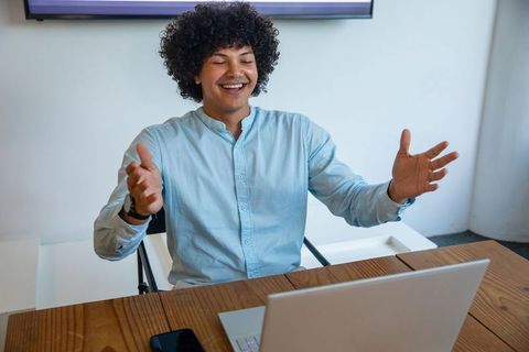 Smiling Young Man Video Conferencing in Modern Home Office