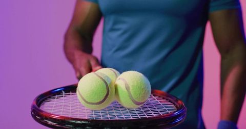 Tennis Player Balancing Balls Under Glowing Studio Lights