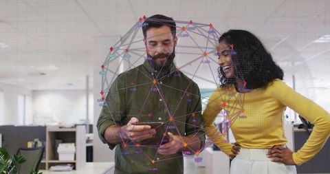 Coworkers collaborating over smartphone with digital network overlay in modern open office