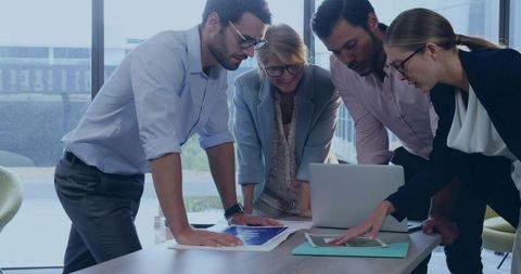 Multigenerational Business Team Collaborating at Table, Reviewing Strategy Plans and Analytics