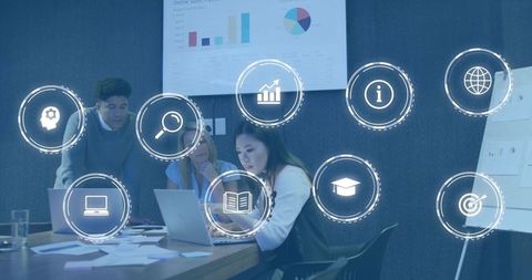 Business team collaborating over laptop with analytics and ux icons overlay