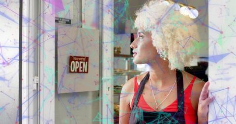 Bakery attendant welcoming customers with pastries and open sign