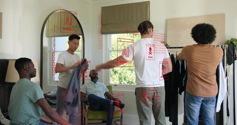 Mens wardrobe styling team collaborating on outfit selection in bright residential studio